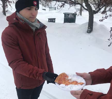 Zachary Nislick ’19 delivering warm pizza with snow on it. Photo by Andrew Wojtowicz.