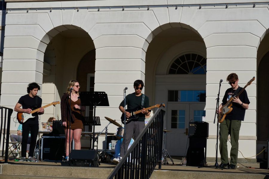 (Left to Right) Daniel Tyebkhan 23, Olivia Brand 23, Vu Le 23, Cray Case 25 (in the back), and Max Taylor 23  perform in front of the Schaffer Library Plaza. They are known as Common Interest, and they deliberately chose songs that have a sustainability-related message.