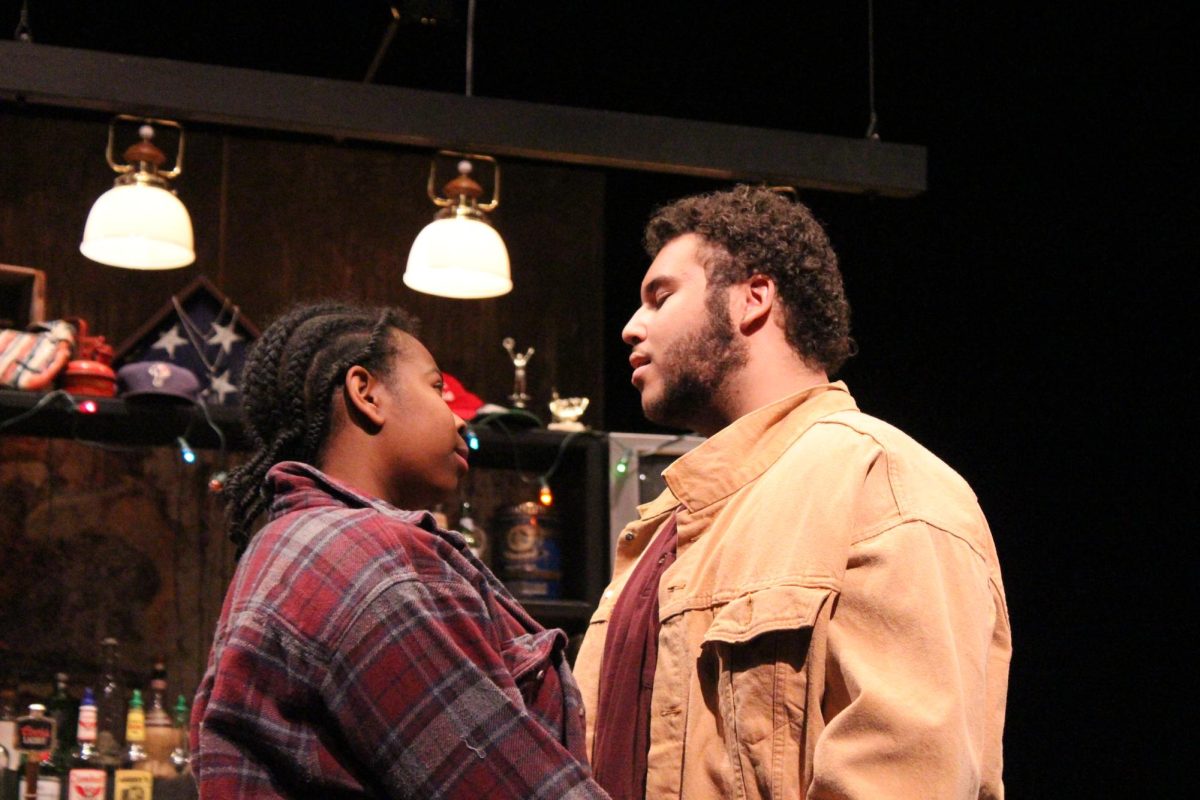 Evan, played by Anthony Montas ‘26, and Cynthia, played by Jolita Brettler ‘25, sharing an embrace in the bar.