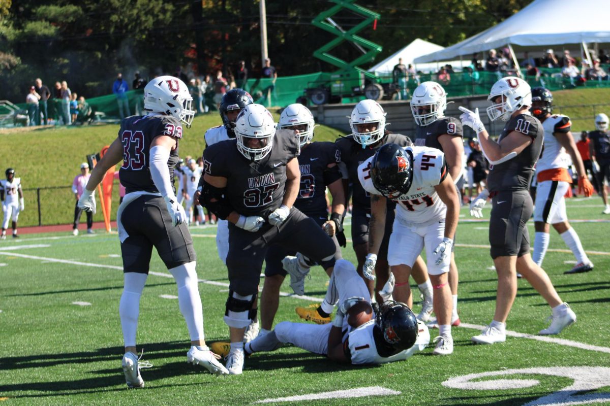 Members of Union’s football defensive line celebrating after a tackle.