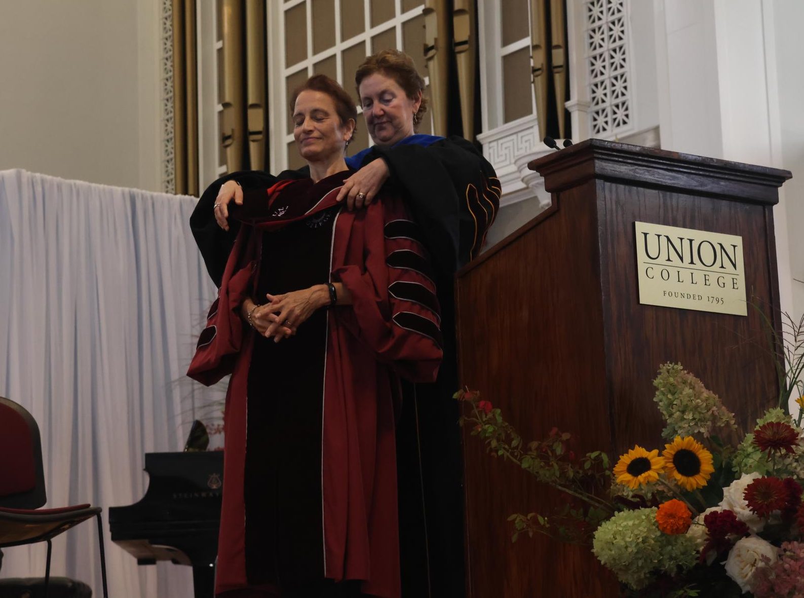 Chair of the Board of Trustees Julie Greifer-Swidler ‘79 adorns President Kiss with a sash during her inauguration.