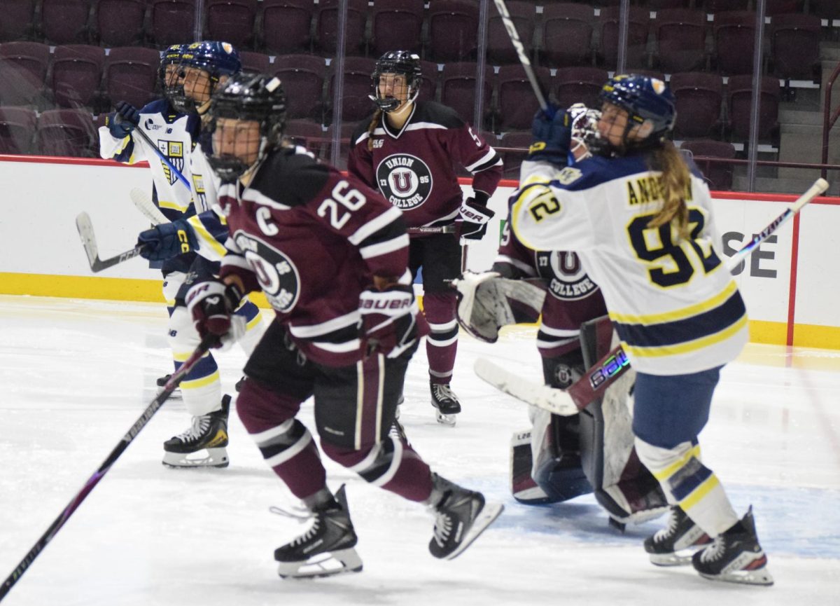 Quinn Dunkle '27, Stephanie Bourque '26, and Monja Wagner '27 defend the net against Merrimack College on October 4, 2025. 