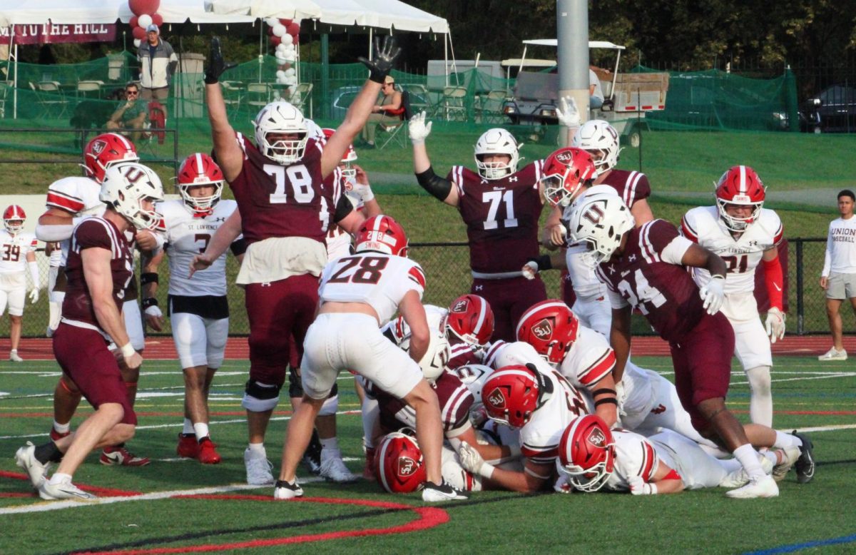 Jack Beacham '28 and David Cooperstein '26 celebrate after Michael Dinardo '27 scores a touchdown at the St. Lawrence game on September 27, 2025.  