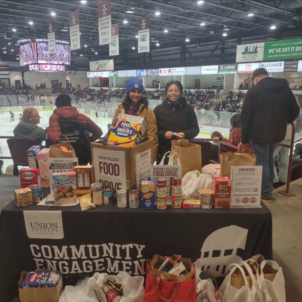 Kenney Center of Community Engagement and Outreach work-study students working at an off-campus hockey game
